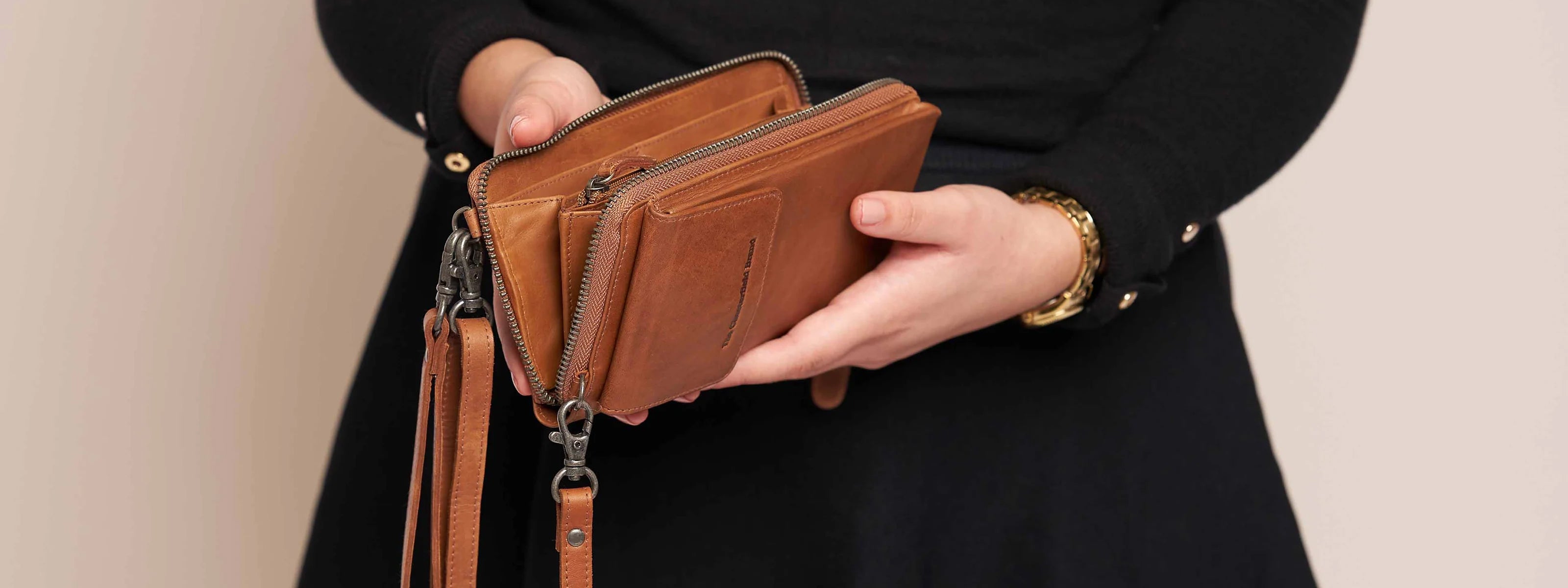 Kvinna som håller i en plånbok i läder som är öppen